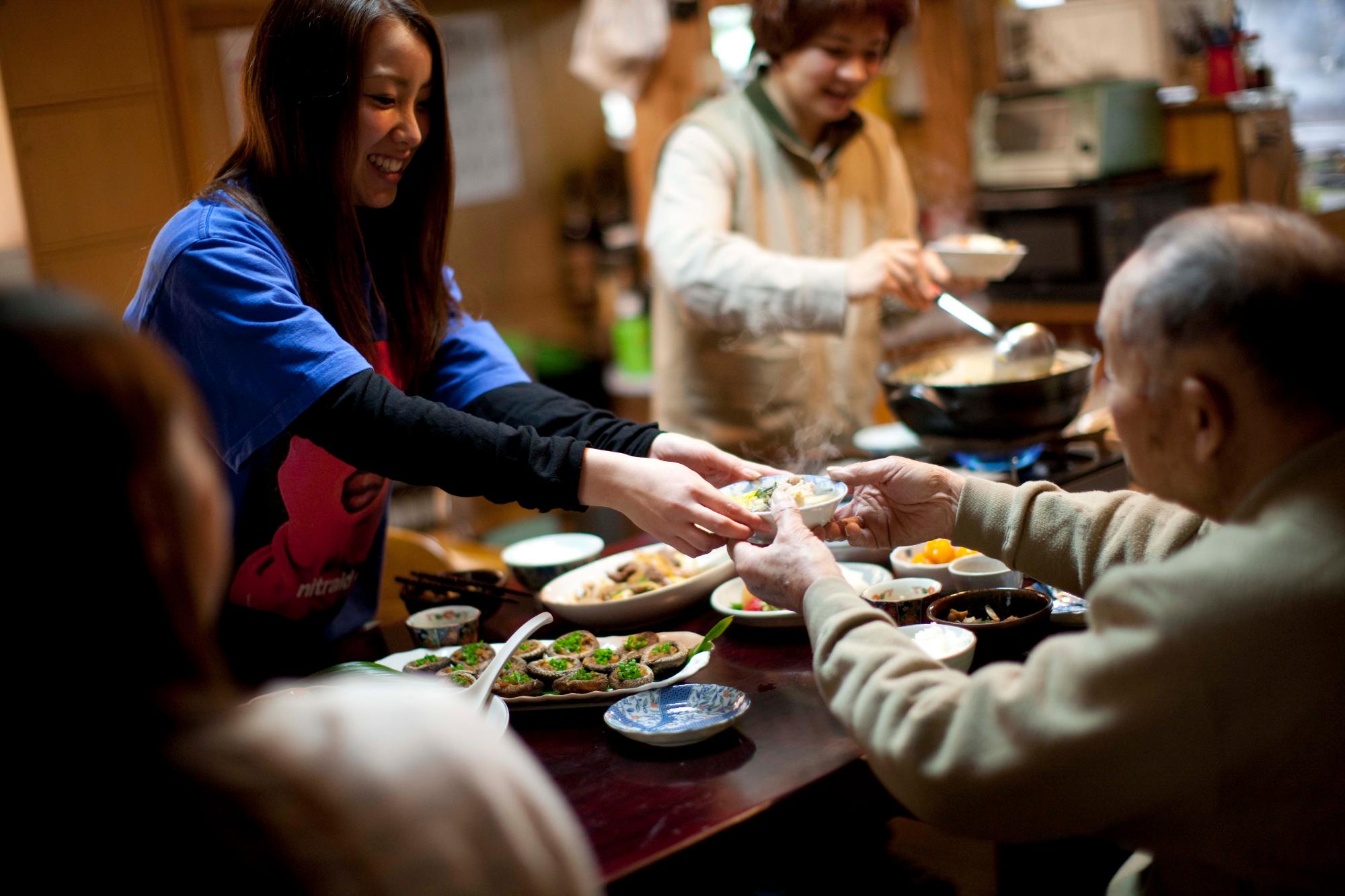 地域の方と食卓を囲み交流する旅行者
